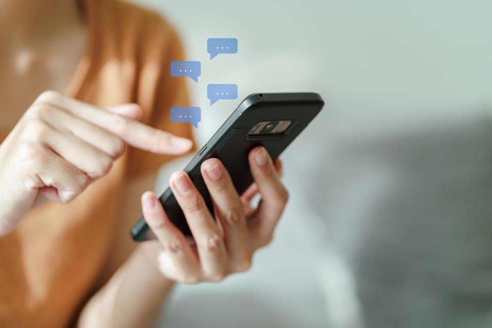 Photo d'une femme qui reçoit des sms sur son smartphone