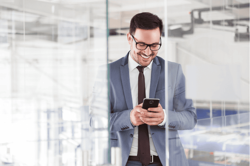 Un homme souriant sur son téléphone